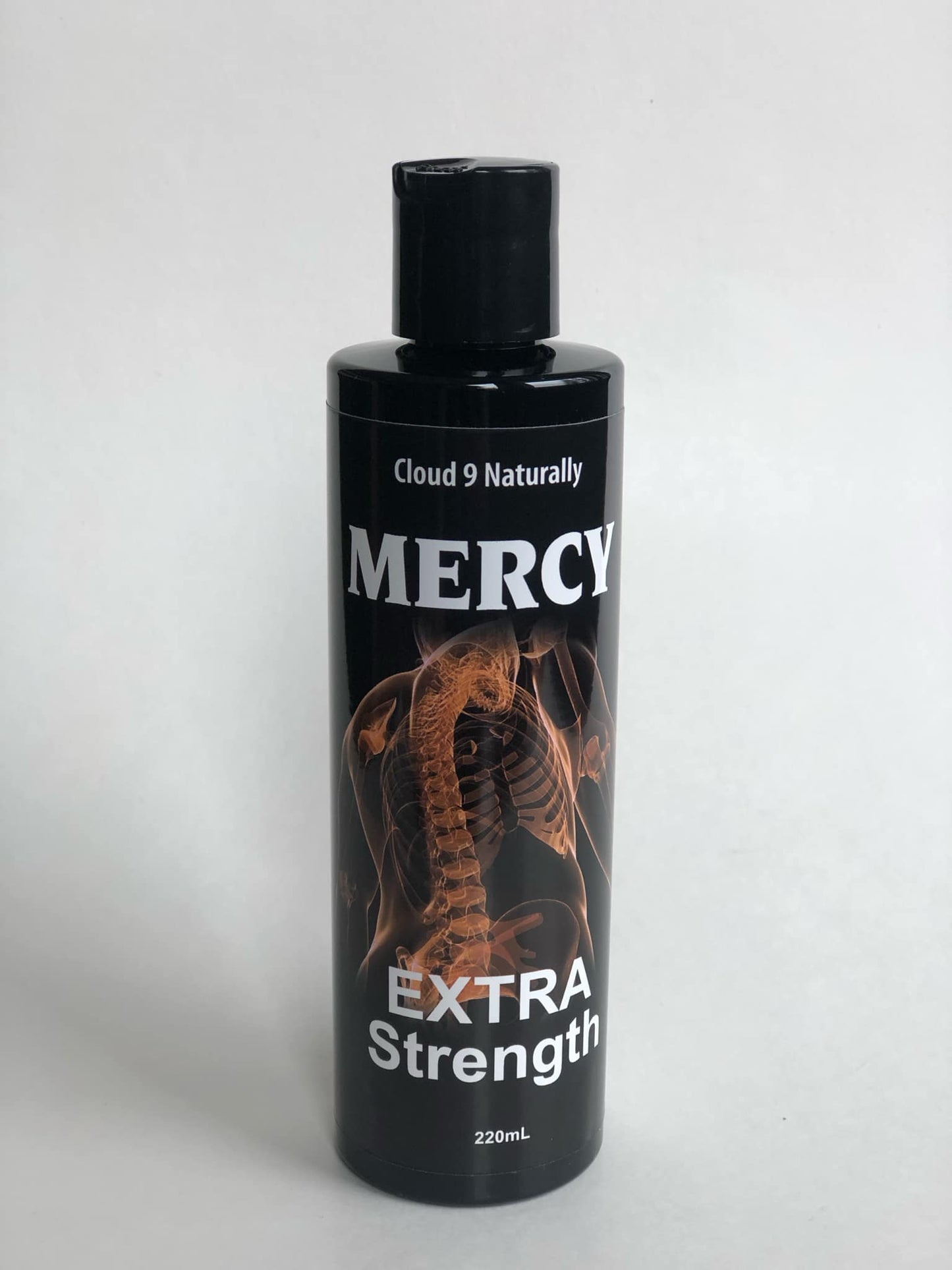 Mercy Extra strength 220ml black plastic bottle with flip top,  label has a picture of an orange colored spine skelaton with white lettering.