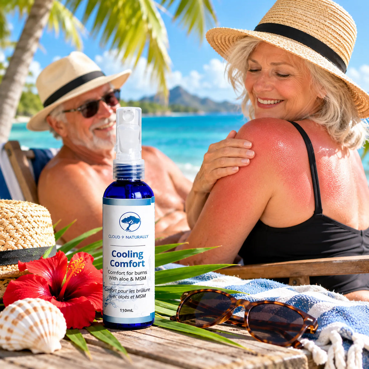 A bottle of Cooling Comfort spray stands on a beach table in front of a couple relaxing at the beach. The woman has sunburned skin on her shoulder.