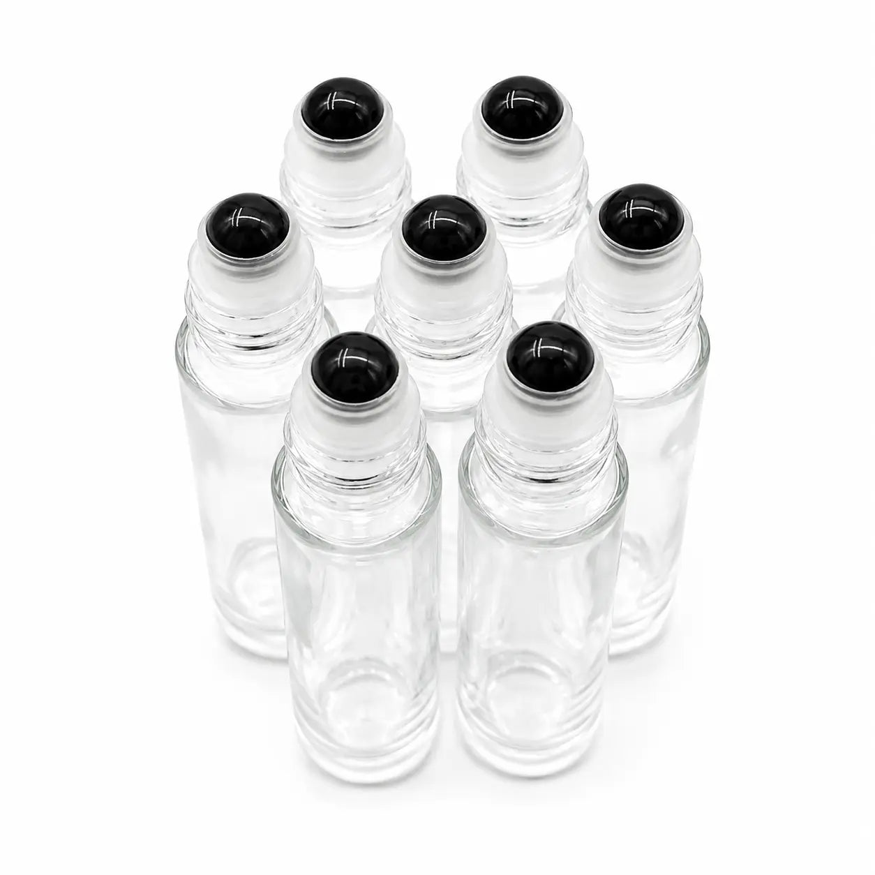 Six clear glass rollerball bottles with black obsidian gemstone roller tops, arranged in circle on  white background.