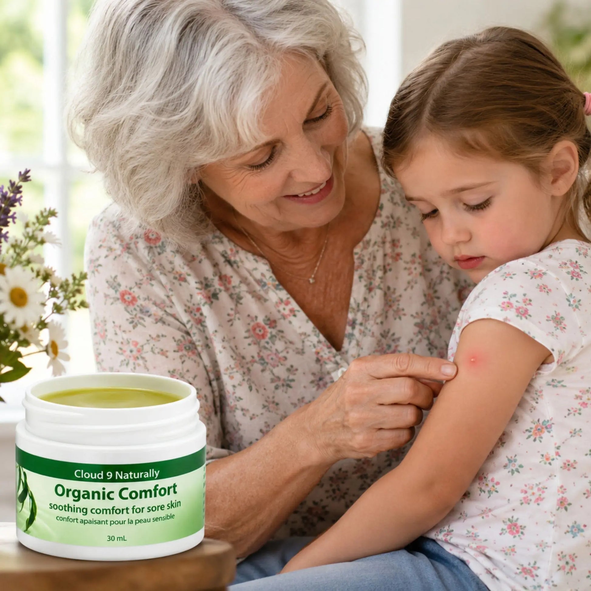 Woman applying cream to a child's arm with a jar of Cloud 9 Naturally Organic Comfort cream in the foreground.